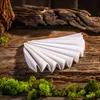 A white pleated filter is laid out on a rustic wooden surface, with moss and driftwood in the background. Anteprima dell’immagine prodotto