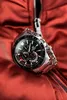 A close-up shot of a Casio Edifice watch resting on a red fabric surface, possibly a jacket, with a zipper visible. Voir les images du produit