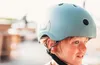 A young boy wearing a light blue helmet, outdoors. Podgląd zdjęcia produktu