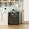 A kitchen cart with storage and shelves is shown in a kitchen setting next to a cabinet and a door. Náhled obrázku produktu