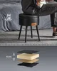 A person sitting on a black stool with legs. A diagram showing the layers of the stool's cushion is below. Náhled obrázku produktu