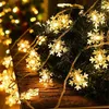 Close-up of snowflake-shaped string lights on a Christmas tree branch. Produktbild-Vorschau