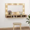 A vanity mirror with LED lights and storage shelves mounted on a white wall, with a stool in front. Náhľad obrázku produktu