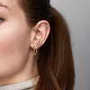Close-up of a woman's ear adorned with multiple earrings. Náhľad obrázku produktu