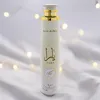 A bottle of air freshener is displayed against a soft, white, textured background with blurred bokeh lights. Podgląd zdjęcia produktu
