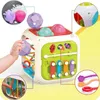 A baby's hand interacting with a colorful activity cube toy, with close-up insets highlighting different features of the toy. Produktbild-Vorschau