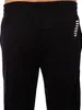 A close-up view of black sweatpants with a white logo on the side. Produktbild-Vorschau