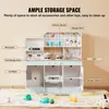 A children's toy kitchen set with various labeled features and accessories on a rug. Produktbild-Vorschau