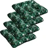 A stack of four square seat cushions with a tropical leaf pattern.