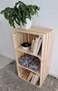 A wooden crate shelf with a plant on top and decorative items on the shelves. Produktbild-Vorschau