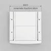 A white appliance accessory mounted on a light gray wall. Podgląd zdjęcia produktu