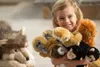 A young girl is holding several stuffed monkey toys. Anteprima dell’immagine prodotto