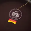 A close-up of a product tag attached to a dark-colored pan. Náhľad obrázku produktu