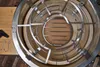 Close-up view of the inside of a grill, showing a metal rack and a circular grate with wooden slats. Produktbild-Vorschau