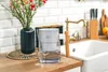 A water filter pitcher sits on a kitchen counter next to a vase of flowers and a sink. Podgląd zdjęcia produktu