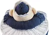 A close-up view of a stuffed toy sailor bear sitting in a white wicker laundry basket. Anteprima dell’immagine prodotto