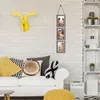 A living room scene with a couch, pillows, and wall decorations. Produktbild-Vorschau