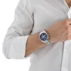 A man wearing a white shirt and a silver watch with a blue face. Podgląd zdjęcia produktu