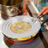 A person is using tongs to hold a splatter screen over a frying pan on a stovetop. Produktbild-Vorschau