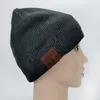 A dark gray knitted beanie with a brown faux leather patch on the side, displayed on a mannequin head. Anteprima dell’immagine prodotto