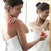 A woman is applying a product to her shoulder, which appears to be sunburned. Náhľad obrázku produktu