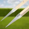 Two metal-tipped wooden posts with metal collars are shown in front of a blurred green hedge and blue sky. Produktbild-Vorschau