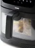 Close-up of a black air fryer with a handle and a transparent window showing french fries inside. Podgląd zdjęcia produktu
