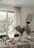 A dining table set for a meal with cutlery, plates, bread, a decorative pumpkin, and a floral arrangement. Náhled obrázku produktu