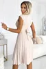 A woman wearing a beige dress in a room. Produktbild-Vorschau