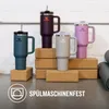 Four Stanley Quencher H2.0 Flowstate tumblers are displayed on cork blocks in front of a white brick wall. Produktbild-Vorschau