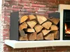 A metal firewood rack filled with logs next to a fireplace. Produktbild-Vorschau