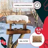 A wooden bird feeder covered in snow, with two birds eating from it, set against a snowy outdoor background. Produktbild-Vorschau
