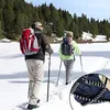 Two people hiking in the snow with backpacks and poles. Anteprima dell’immagine prodotto
