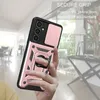 A hand holding a rose gold phone case with a ring holder and camera cover, with a blurred indoor background. Produktbild-Vorschau