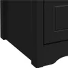 A close-up view of the bottom corner of a black cabinet or furniture piece. Podgląd zdjęcia produktu