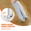 A hand is shown folding a white wall-mounted shower seat against a tiled wall. A close-up inset highlights the linkage mechanism. Produktbild-Vorschau