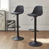 Two black adjustable bar stools are shown in a room with wooden floors and framed artwork in the background. Produktbild-Vorschau