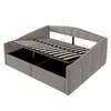 A grey upholstered bed frame with the mattress support slats lifted to reveal storage compartments underneath. Produktbild-Vorschau