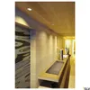 A modern hallway with wooden walls and ceiling, featuring a counter with a sink and decorative elements, illuminated by recessed ceiling lights. Produktbild-Vorschau