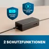 A black laptop power adapter with cables plugged in, placed on a wooden desk. Two blue shield icons with text are displayed above the adapter. Podgląd zdjęcia produktu
