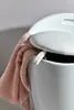 A close-up of a white stool with a pink towel draped over the edge. Produktbild-Vorschau