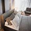 A bedroom scene with a bed, armchair, and side tables. Produktbild-Vorschau