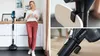 A woman stands in a kitchen next to a cordless vacuum cleaner, with close-up shots of the vacuum's components. Produktbild-Vorschau