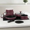 A set of burgundy cookware arranged on a kitchen countertop with a black induction cooktop. Náhľad obrázku produktu