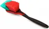 A cleaning brush with red and teal bristles and a black handle, isolated on a white background. Produktbild-Vorschau