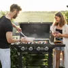 A couple is enjoying a barbecue in a backyard setting during sunset. Produktbild-Vorschau