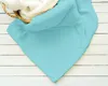 A turquoise blanket is draped over a basket filled with a white fluffy blanket, resting on a white wooden surface. Produktbild-Vorschau
