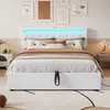 A white upholstered bed with a tufted headboard featuring LED lighting, set in a bedroom with artwork on the wall and a bedside table. Náhled obrázku produktu