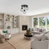 A living room with a fireplace, sofa, and coffee table, featuring a ceiling light. Produktbild-Vorschau