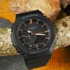 A black G-Shock watch with rose gold accents is resting on a piece of wood and textured rocks. Voir les images du produit